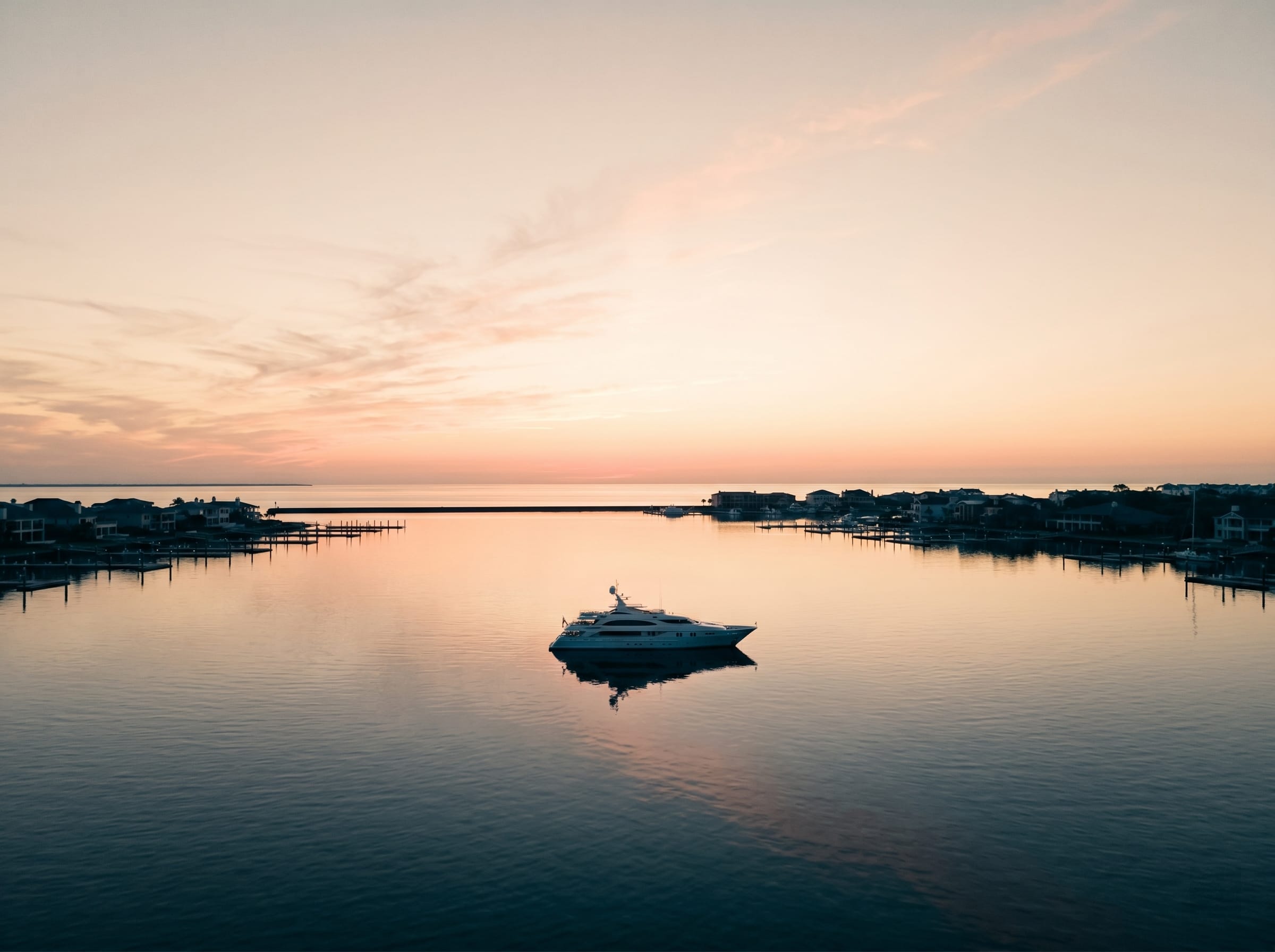 A superyacht at rest on calm golden-hour water